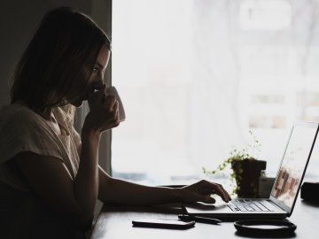Woman on computer drinking coffee